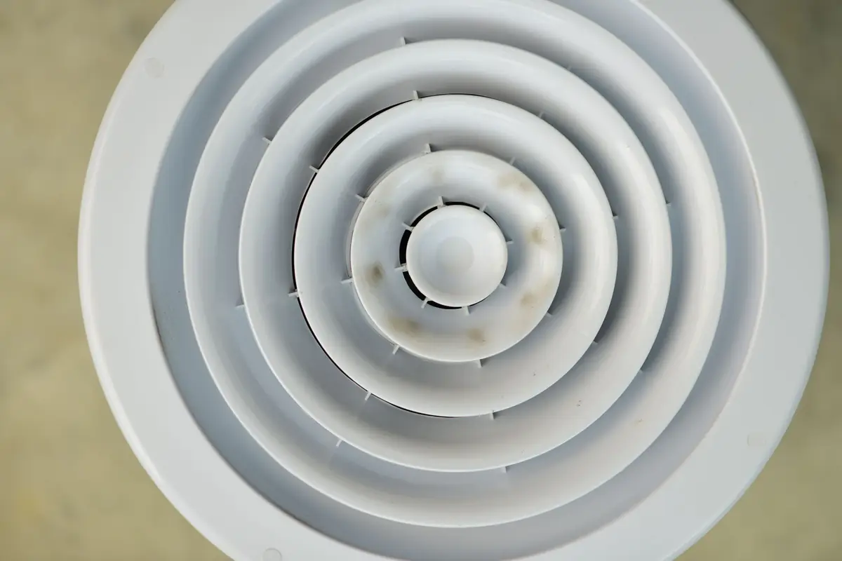 Al Nafeh technician cleaning an AC duct vent in a Dubai apartment
