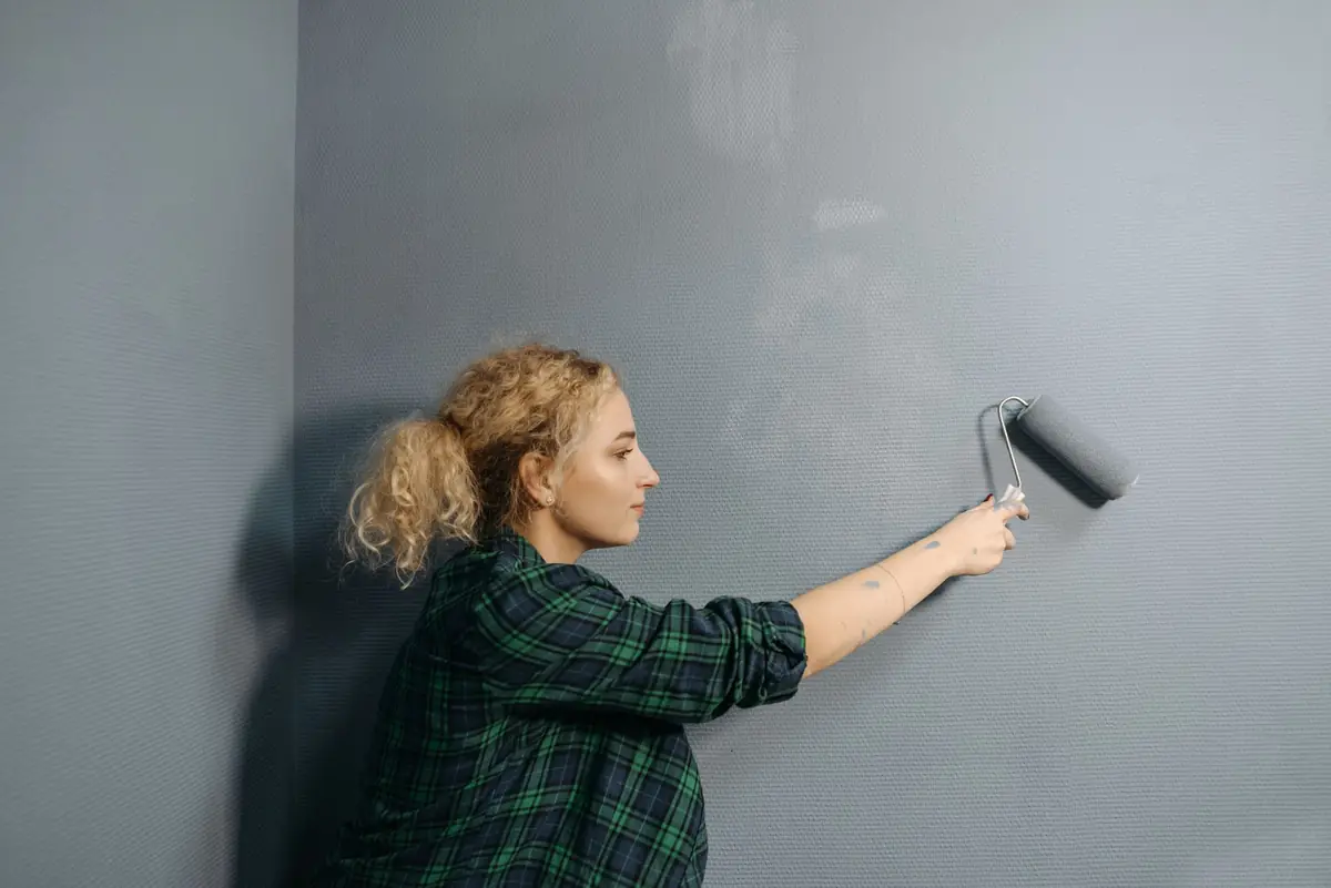 Al Nafeh painter rolling emulsion onto a living room wall in Dubai