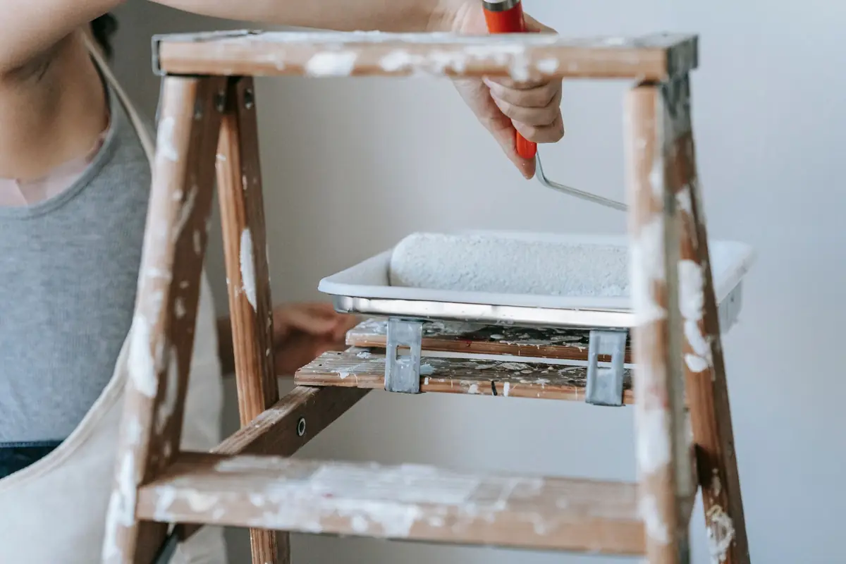 Painter using a roller to paint an interior wall in a Dubai apartment