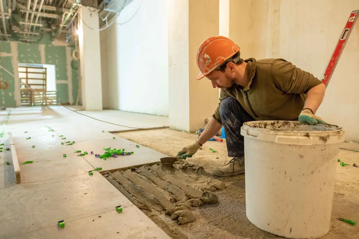 Al Nafeh tiler laying floor tiles in a Dubai apartment